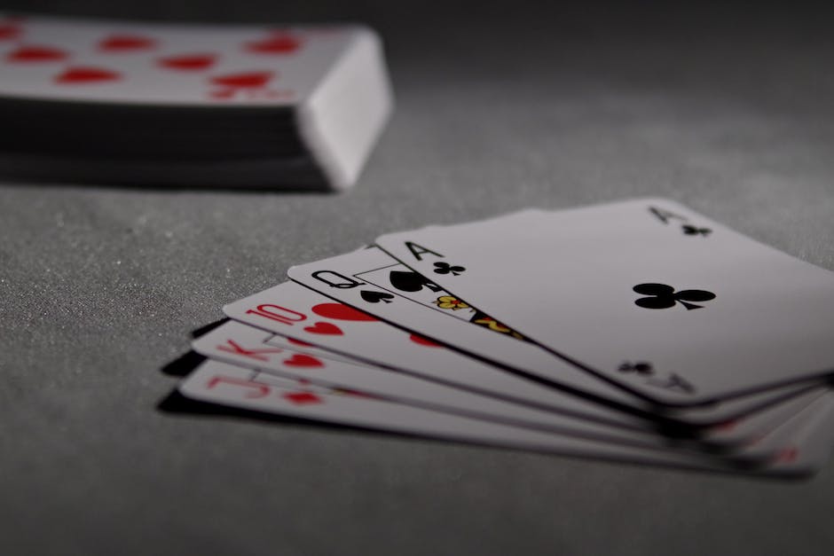 Three players sitting around a table playing Skat, each holding a hand of cards