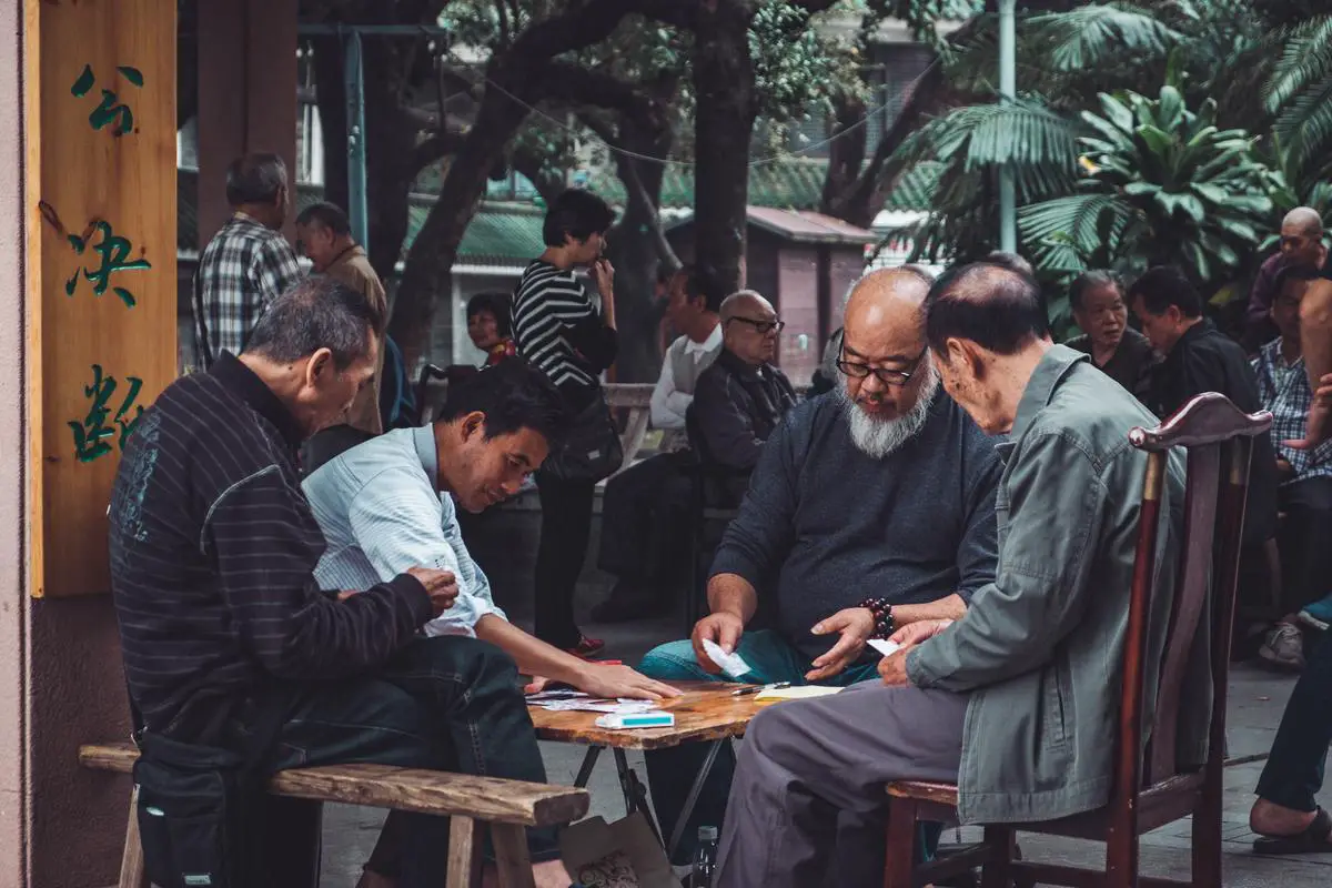 A group of people playing cards and looking engaged with the game.