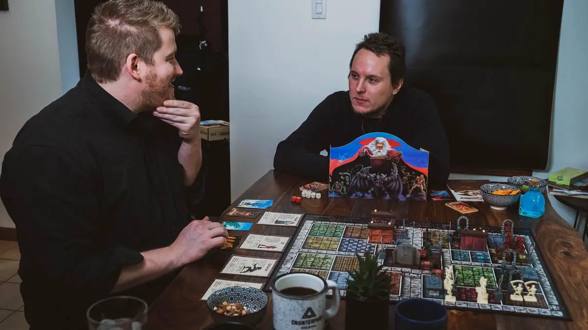 A group of friends sitting around a table playing various board games