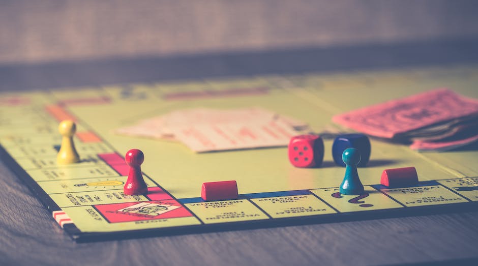 A group of people sitting around a table playing a board game called Cashflow by Robert Kiyosaki