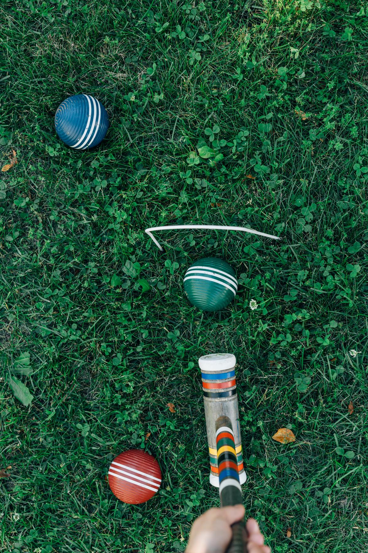 Image of a person playing croquet in a garden