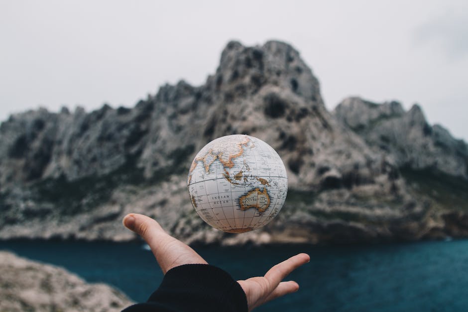 An image showing a person holding a globe, symbolizing the global location guessing game.